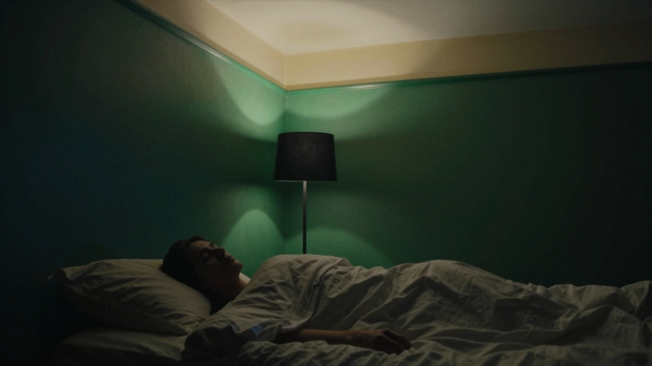 Темно-зелёная стена в спальне ночью с тёплым потолком, человек спит под одеялом в тихой обстановке.
